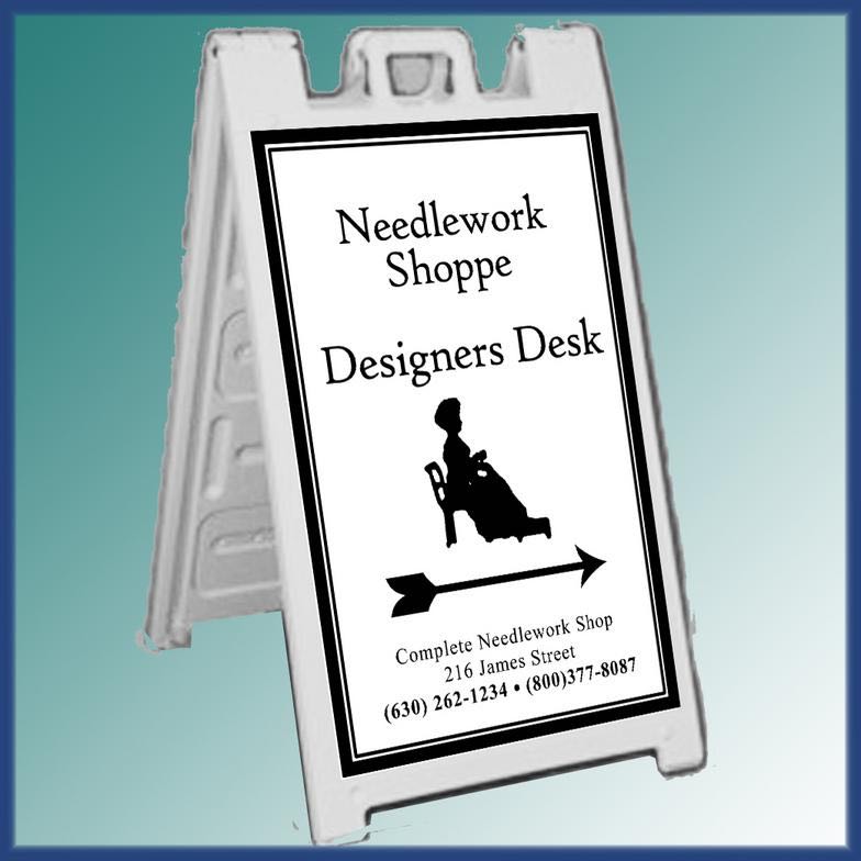 A-frame sidewalk sign for a needlework shop